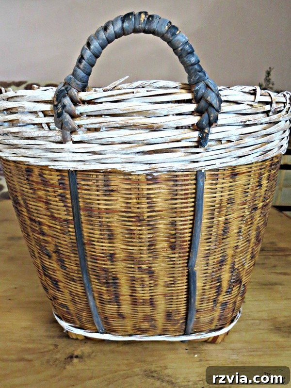 Front view of the painted basket with custom grey handles and vertical reed accents for a stylish DIY look