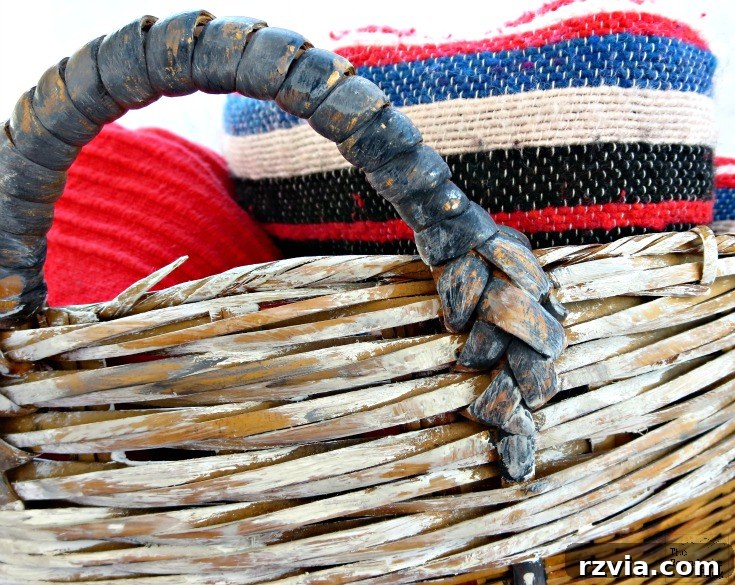 Detail of the artfully distressed paint finish on the top rim of the wicker basket, highlighting its vintage appeal