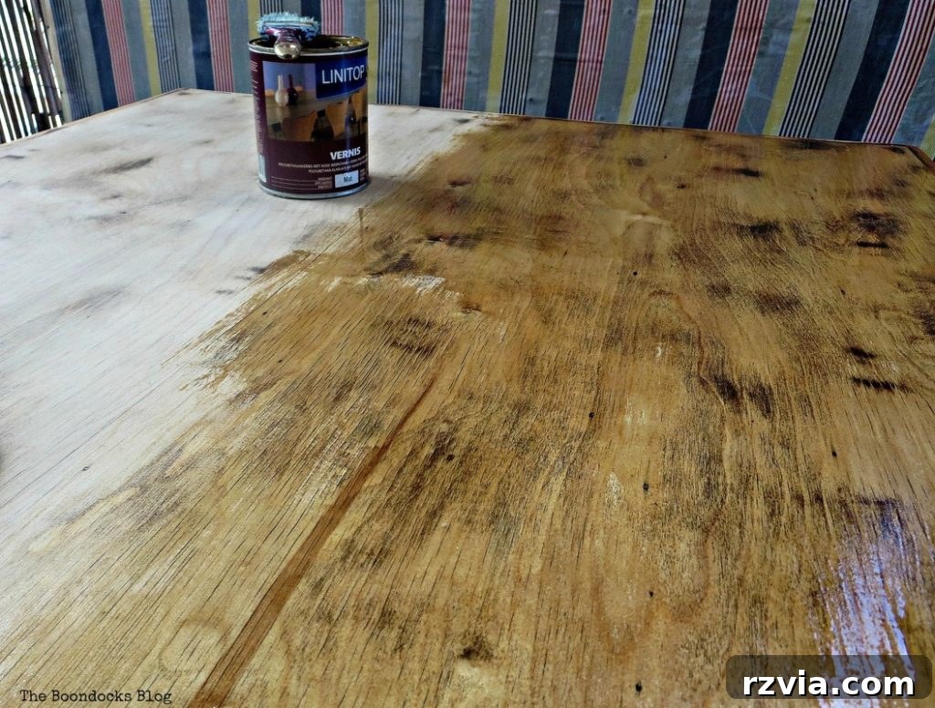 Vibrant Tri-Tone Reclaimed Coffee Table 7 Coffee table top with one coat of varnish applied, showing the wet, slightly yellowed finish contrasted with the raw wood.
