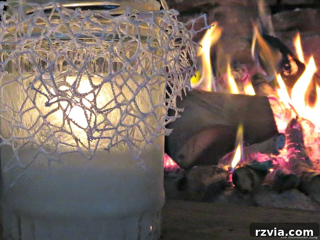 Phantom Snow 15 A lit frosted tealight holder by a fireplace, creating a warm, inviting scene