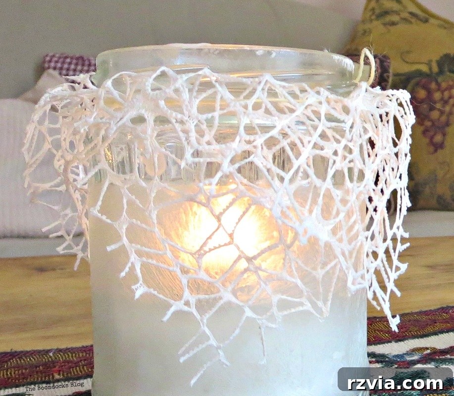 Phantom Snow 9 Close-up of a single lit frosted tealight holder with lace, showing intricate details