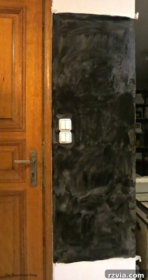 Craft Your Custom Chalkboard Wall 5 Blackboard wall after only one initial coat of chalkboard paint, showing uneven and incomplete coverage. www.theboondocksblog.com
