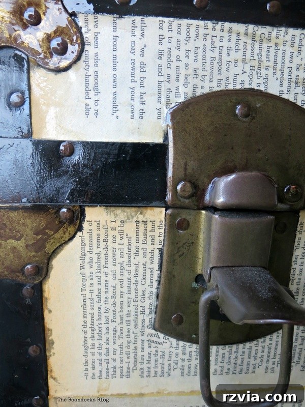 Detail of the metal hardware on the decoupaged trunk, showing the aged finish