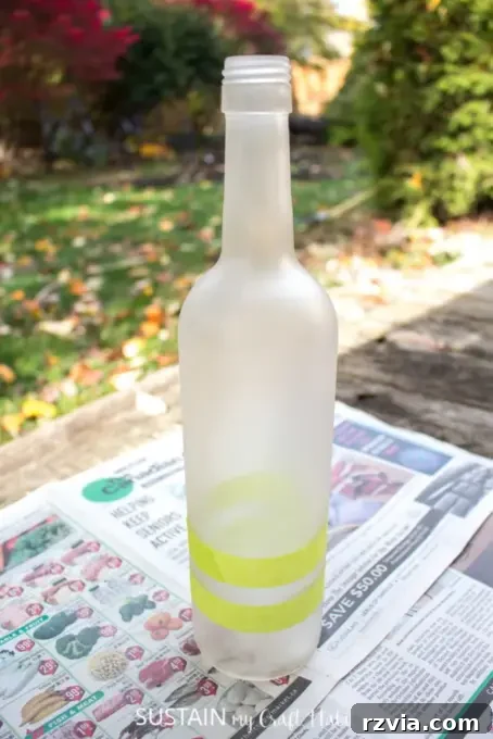 Spraying wine bottle with frosted paint